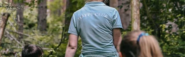 Zwei Damen der Kinderbetreuung im Wald mit einem Kind