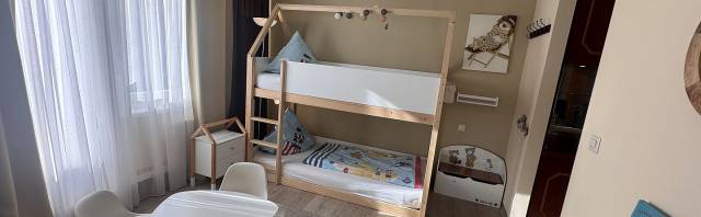 Kinderzimmer mit Doppelbett, Tisch und schönem Teppich
