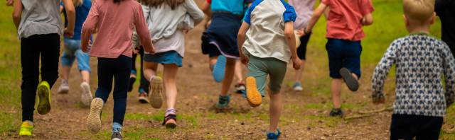 Kinder, die im Rookhus Urlaub machen, laufen durch den tiefen Wald