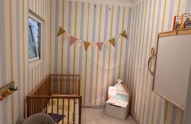 Babyzimmer im Borchards Rookhus mit Bett, Stuhl, Girlande, Wickeltisch