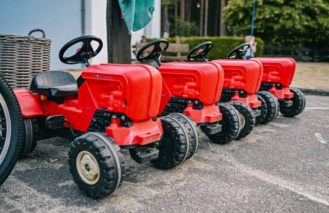 Rote Kindertraktoren parken in einer Reihe 