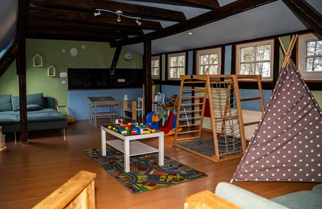 Spielzimmer für Kinder mit Tipi, Klettergerüst, Lego, Tafel und Couch