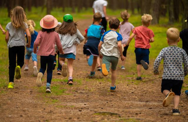 Kinder, die im Rookhus Urlaub machen, laufen durch den tiefen Wald