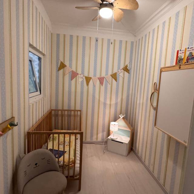 Babyzimmer im Borchards Rookhus mit Bett, Stuhl, Girlande, Wickeltisch