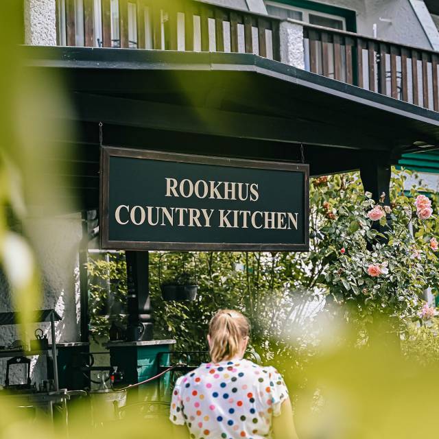 Frau geht auf denRookhus Country Kitchen Eingang zu 