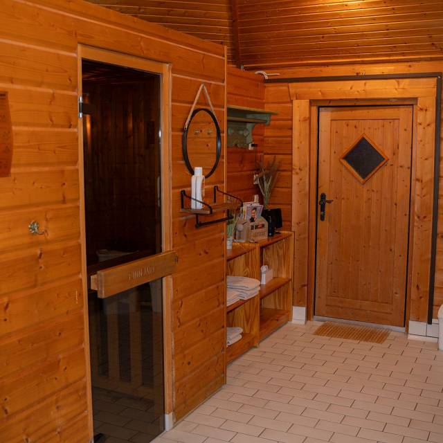 Vorraum der Sauna mit Handtüchern, Regelwerk und Dekoration