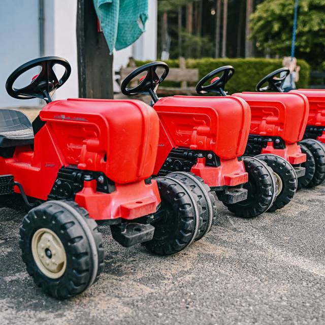 Rote Kindertraktoren parken in einer Reihe 