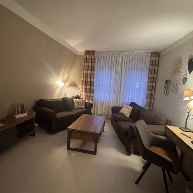 Wohnraum mit Sofas, Sideboard Tisch und Stuhl