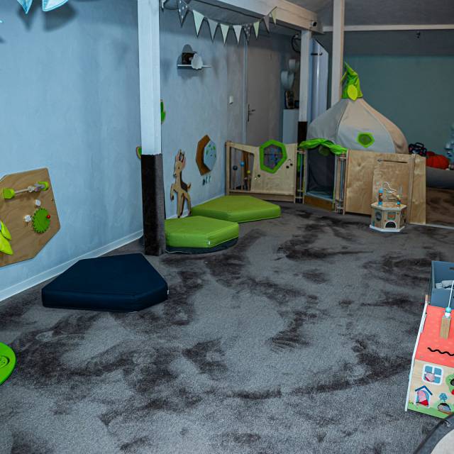 Raum für Kleinkinder mit Teppich, Matten, Tipi und Spielsachen