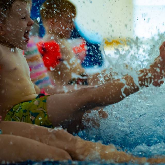 Kinder strampeln mit den Füßen im Pool