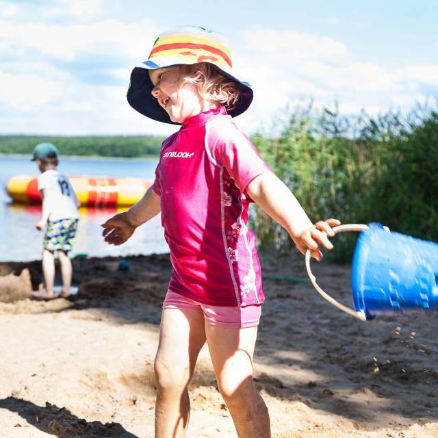 Kind spielt am hoteleigenen Strand am Labussee
