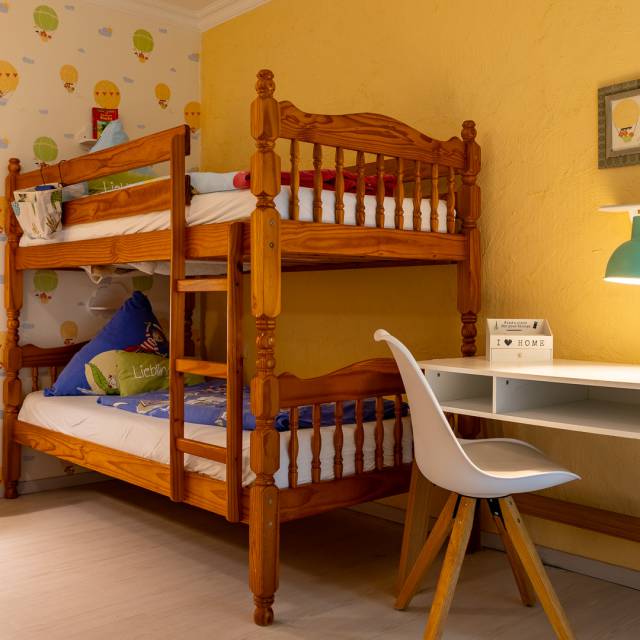 Gemütliches Familienzimmer mit Holzmöbeln und Stockbett für Kinder