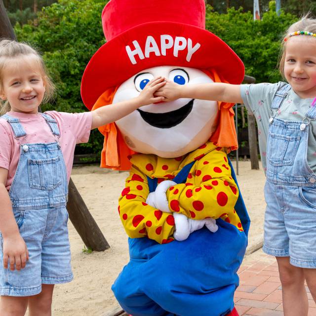 Kinder mit Familotel Maskottchen Happy beim Familienurlaub