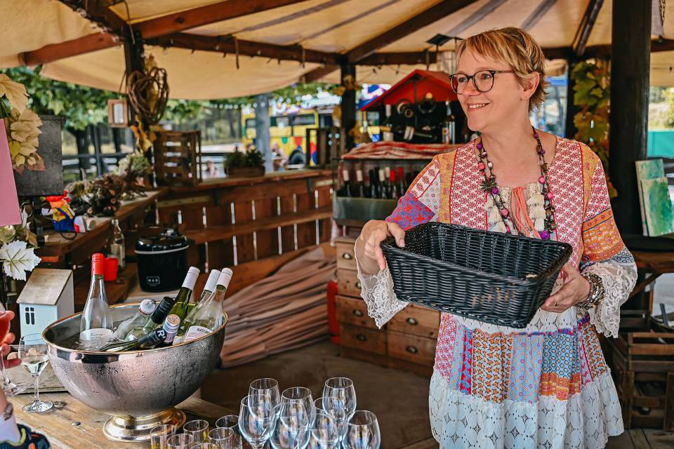 Gastgeberin Andrea im Weinprobierstand mit Korb in den Händen
