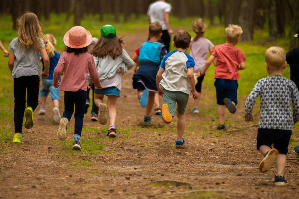 Kinder, die im Rookhus Urlaub machen, laufen durch den tiefen Wald
