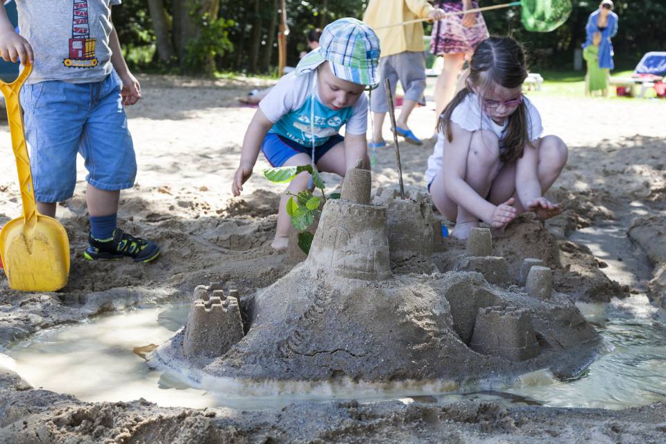Kinder bauen eine Sandburg
