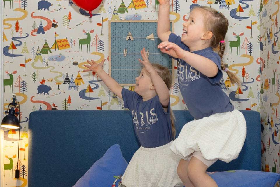 Kinder springen auf dem Bett im Kinderzimmer des Familotels Rookhus
