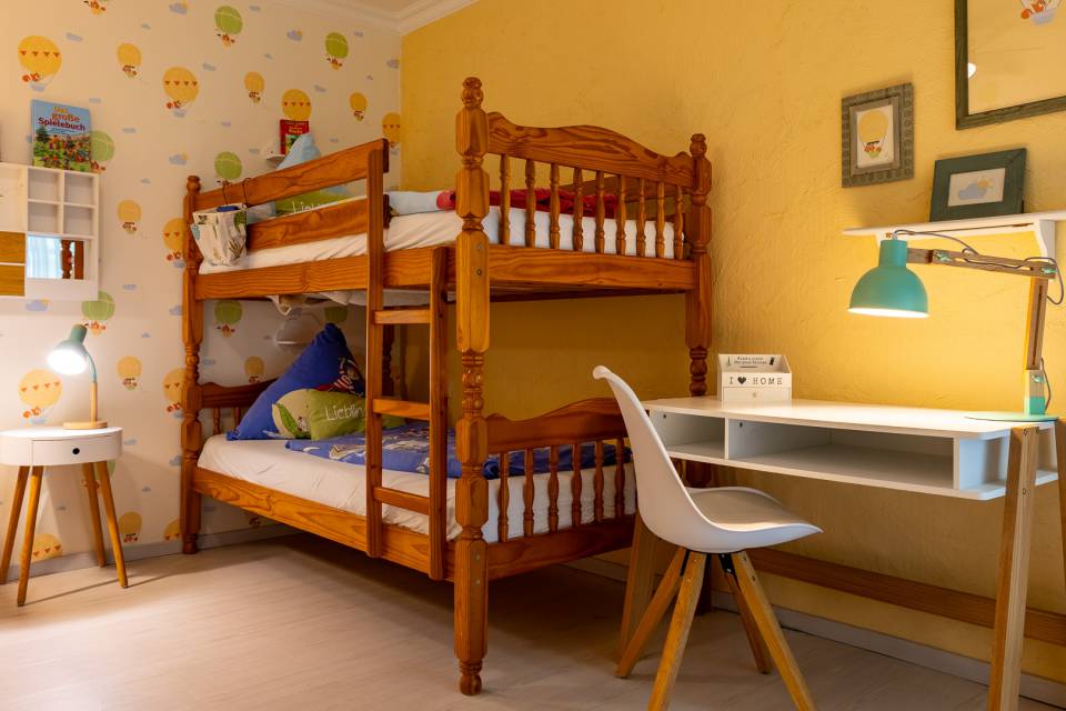 Gemütliches Familienzimmer mit Holzmöbeln und Stockbett für Kinder