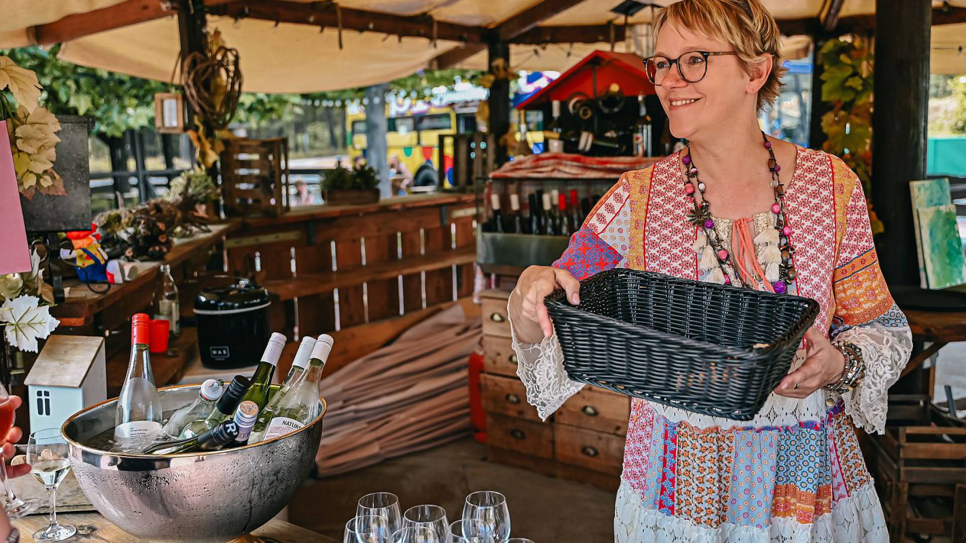 Gastgeberin Andrea im Weinprobierstand mit Korb in den Händen