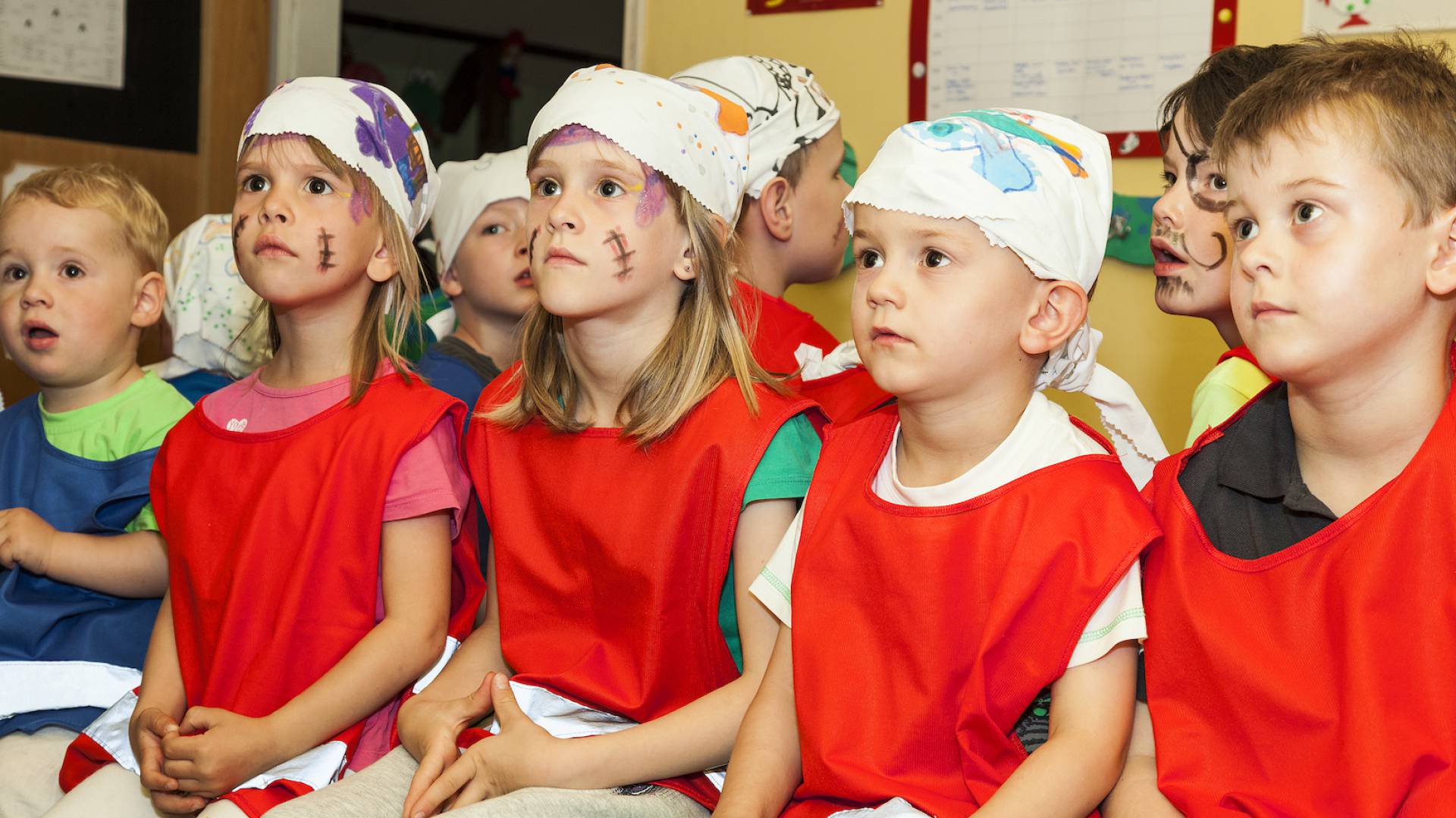 Kinder sitzen als Piraten verkleidet nebeneinander
