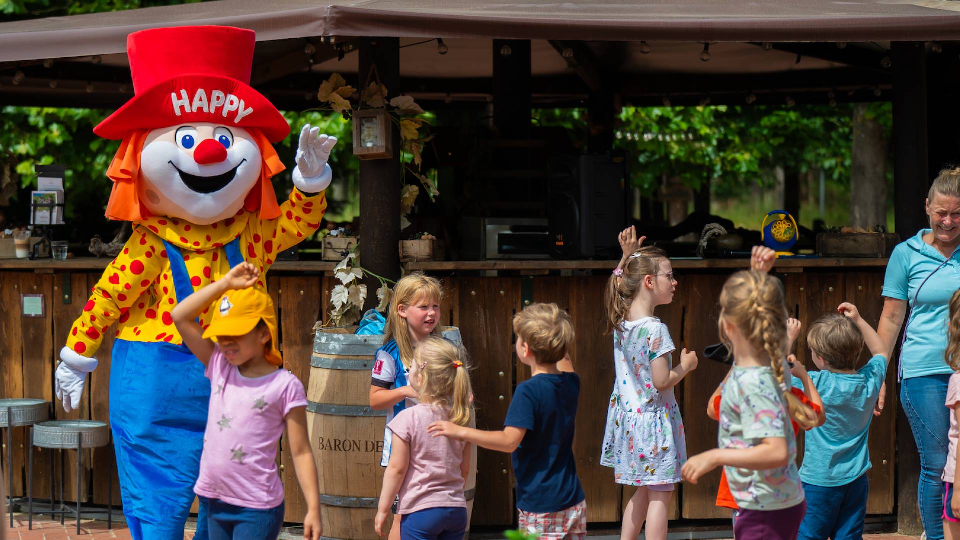 Kinder tanzen mit dem Maskottchen Happy