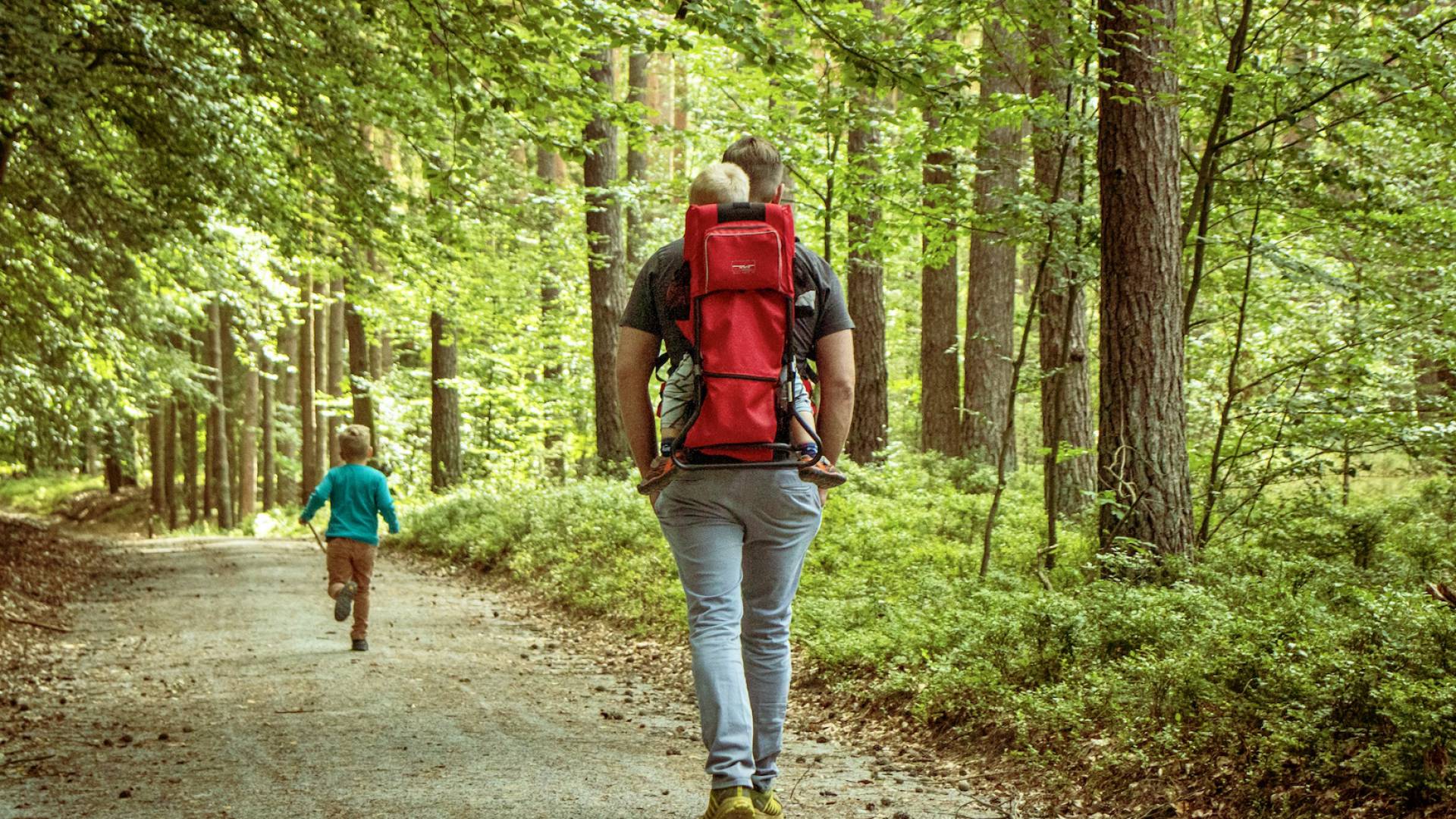 Vater mit zwei Kindern durch den Wald
