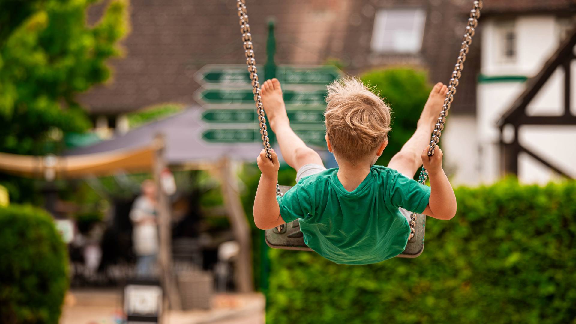 Junge schaukelt im familienfreundlichen Garten des Rookhus in Wesenberg