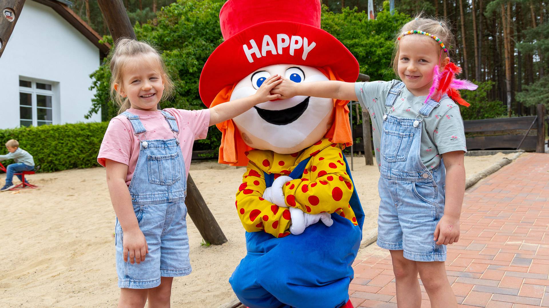 Kinder mit Familotel Maskottchen Happy beim Familienurlaub