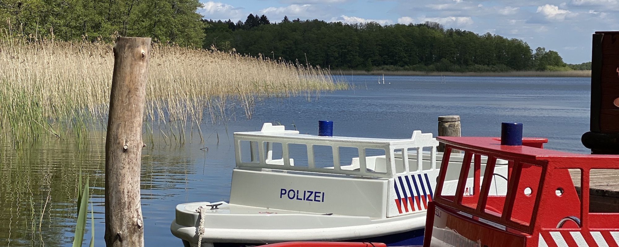 Familienhotel Borchard`s Rookhus an der Mecklenburgischen Seenplatte: zwei Boote (Polizei- und Feuerwehrboot) liegen am Steg am Labussee an
